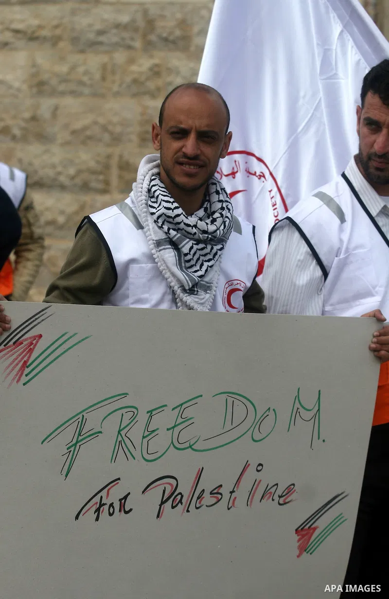 Staff of the Palestinian Red Crescent Society, wave flags and banners during a rally in solidarity with prisoners in Israeli jails, in the West Bank city of Ramallah, April 19, 2012. Photo by Issam Rimawi