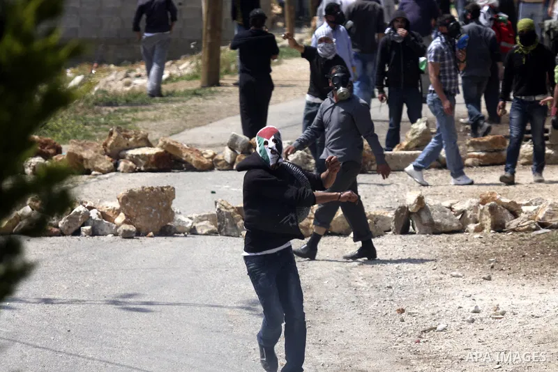 A Palestinian protester readies to throw a stone at the Israeli military during a demonstration against the expropriation of Palestinian land by Israel in the village of Kafr Qaddum, near the northern city of Nablus in t...
