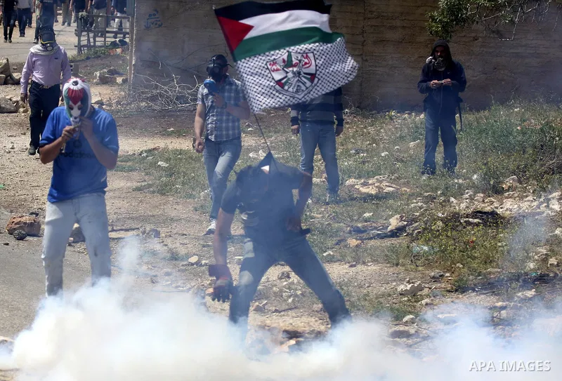 Palestinians protester readies to throw a stone at the Israeli military during a demonstration against the expropriation of Palestinian land by Israel in the village of Kafr Qaddum, near the northern city of Nablus in th...