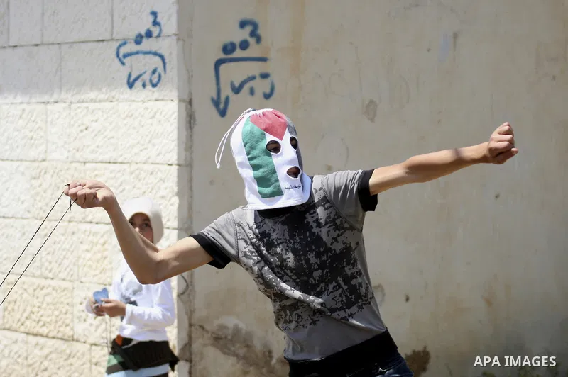 A Palestinian protester readies to throw a stone at the Israeli military during a demonstration against the expropriation of Palestinian land by Israel in the village of Kafr Qaddum, near the northern city of Nablus in t...