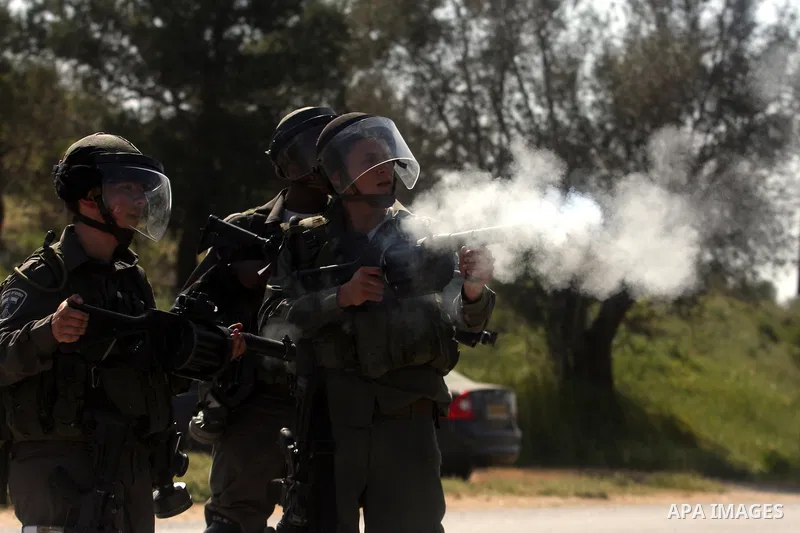 Smoke is seen from the barrel of a rifle after being fired by an Israeli soldier towards Palestinian protesters during clashes in the weekly Friday demonstration in the West Bank village of Nabi Saleh, on April 20, 2012,...