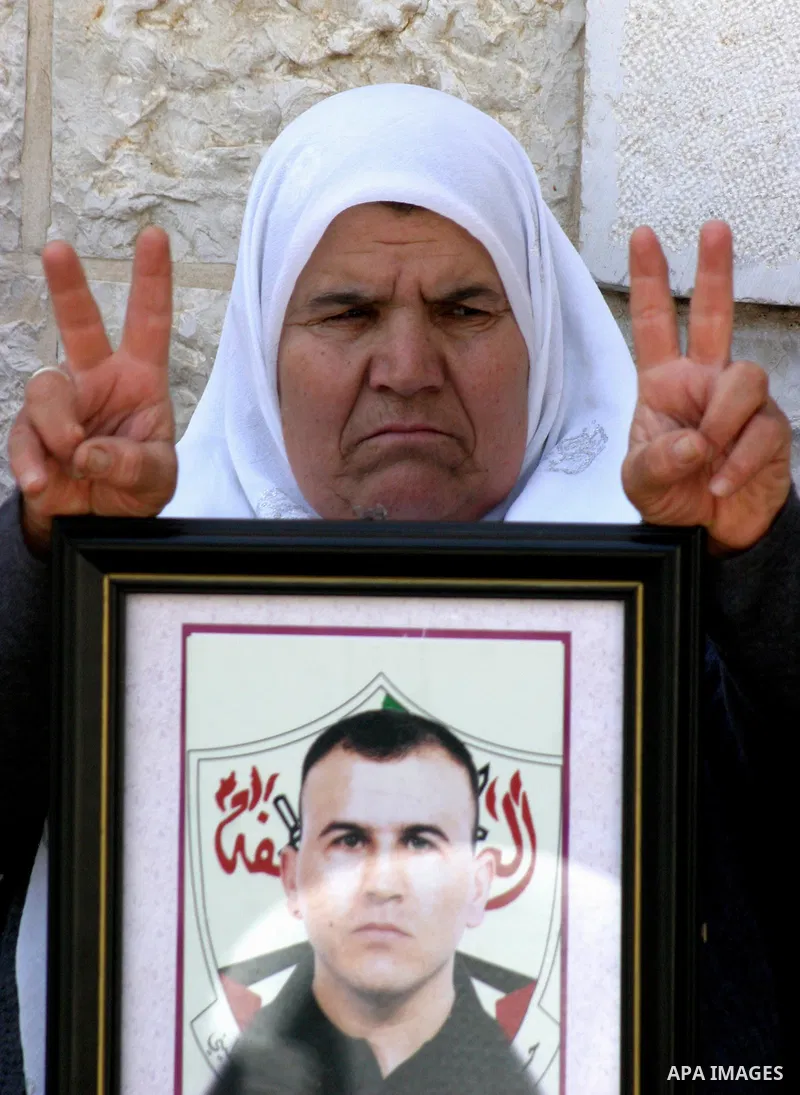 Palestinians hold pictures of a relatives currently being held in an Israeli jail, during a rally outside of the International Red Cross building in east Jerusalem, on April 20, 2012. Photo by Mahfouz Abu Turk