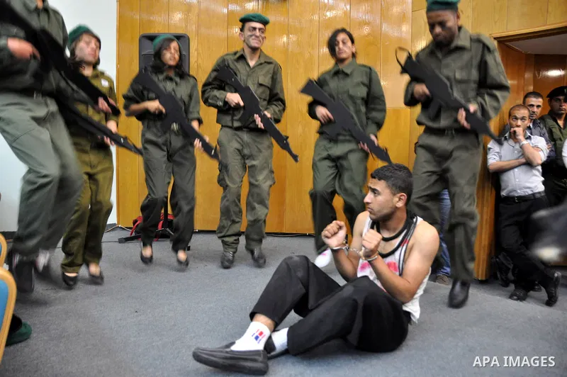 Palestinian actors from Al-Najah university, perform a play, appear Israeli soldiers arrest a Palestinian youth and investigate him in the West Bank city of Nablus, on April,22 2012. Photo by Nedal Eshtaya