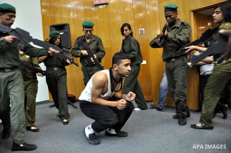 Palestinian actors from Al-Najah university, perform a play, appear Israeli soldiers arrest a Palestinian youth and investigate him in the West Bank city of Nablus, on April,22 2012. Photo by Nedal Eshtaya