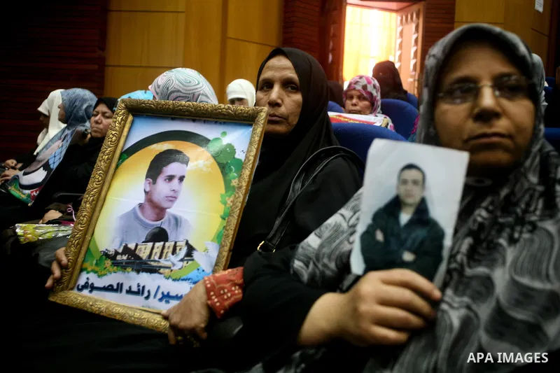 A Palestinian woman holding up a portrait of a jailed loved one takes part in a protest outside the Red Cross offices in Gaza City on April 23, 2012. Photo by Ali Jadallah
