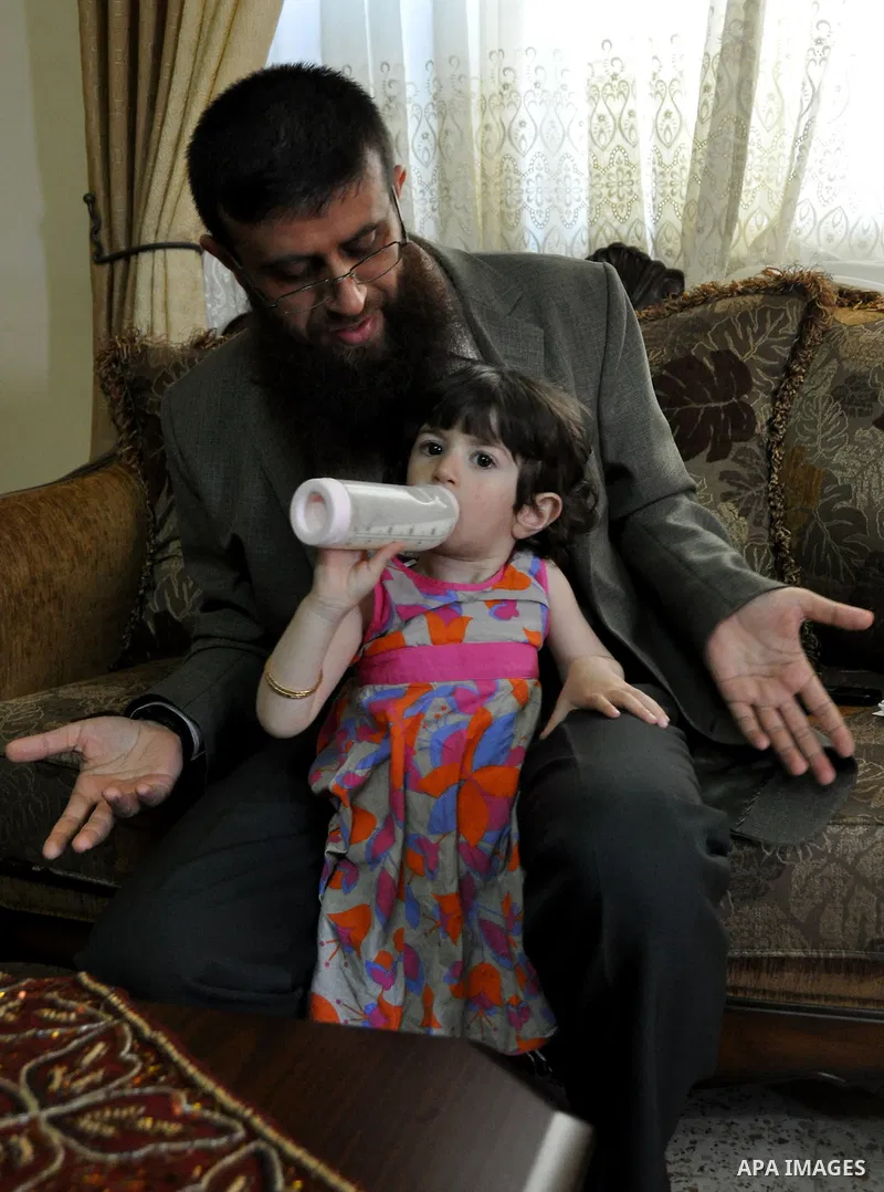 Former Palestinian hunger strike prisoner Khader Adnan, a senior member of Islamic Jihad who was jailed in Israel, plays with a child at his house in the village of Arraba near the northern city of Jenin, in the Israeli...