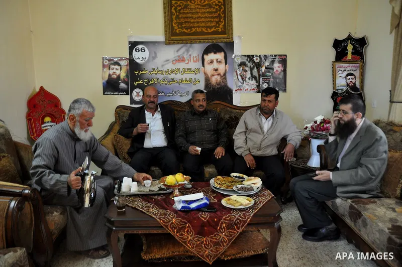Former Palestinian hunger strike prisoner Khader Adnan, a senior member of Islamic Jihad who was jailed in Israel, sits with relatives at his house in the village of Arraba near the northern city of Jenin, in the Israeli...