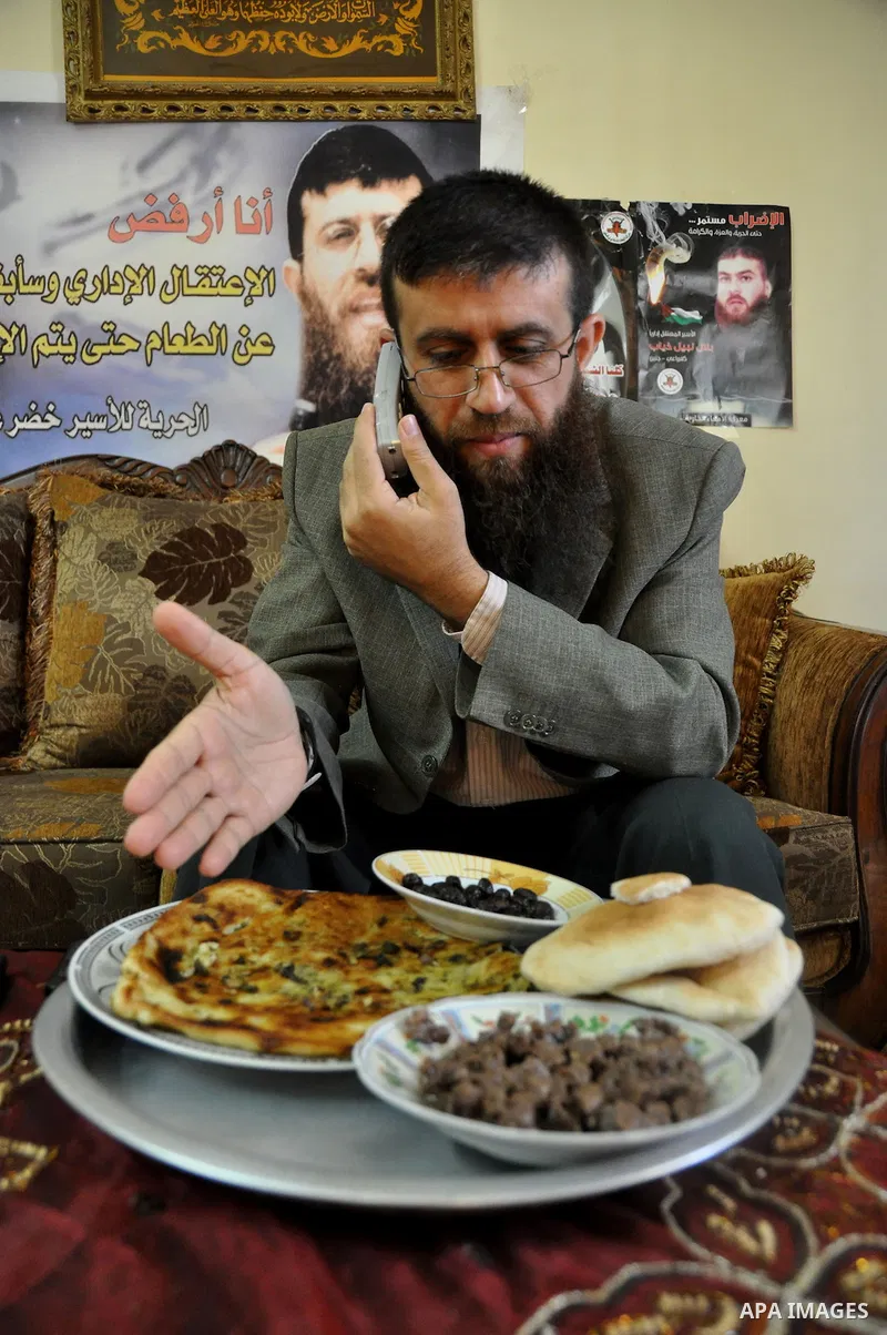 Former Palestinian hunger strike prisoner Khader Adnan, a senior member of Islamic Jihad who was jailed in Israel, uses his mobile at his house in the village of Arraba near the northern city of Jenin, in the Israeli occ...