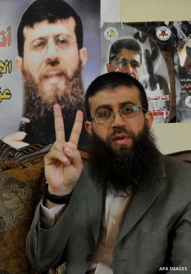 Former Palestinian hunger strike prisoner Khader Adnan, a senior member of Islamic Jihad who was jailed in Israel, shows the victory sign at his house in the village of Arraba near the northern city of Jenin, in the Isra...