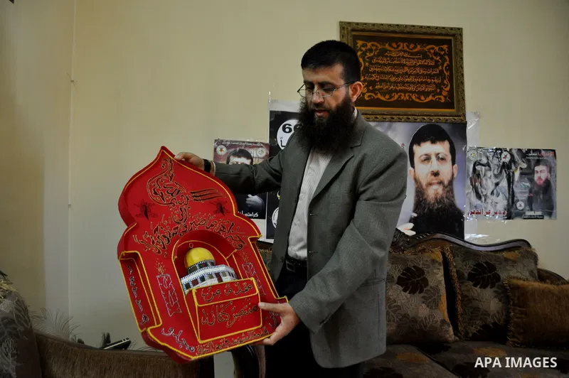 Former Palestinian hunger strike prisoner Khader Adnan, a senior member of Islamic Jihad who was jailed in Israel, holds a model of the Dome of the Rock at his house in the village of Arraba near the northern city of Jen...