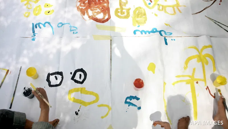 Palestinian disabled children use their feet to draw and paint pictures at a charity association during a celebration in Gaza city on April 23,2012. Photo by Ali Jadallah