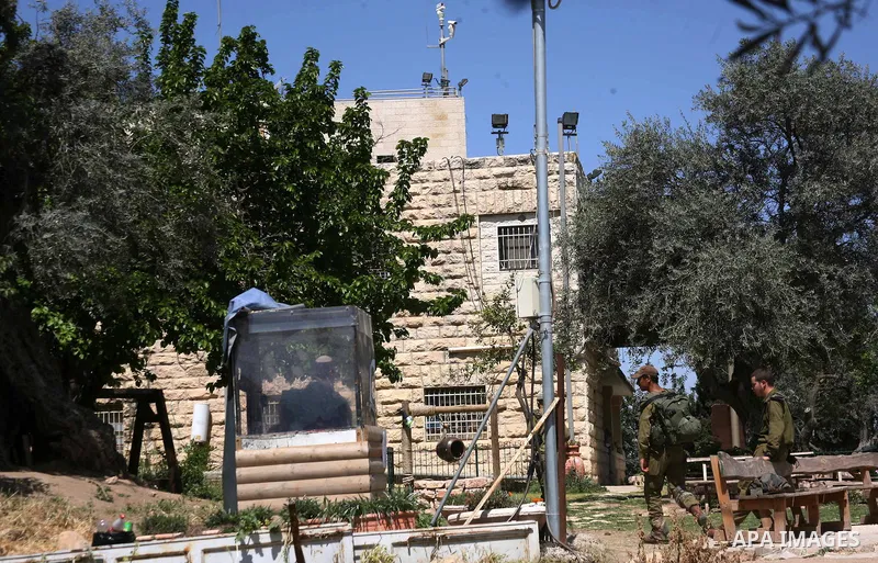 Israeli soldiers stand guard in the garden of a Palestinian house in the southern West Bank city of Hebron from which an Israeli court ordered the Israeli settlers out by May 15 after ruling on April 23, 2012 that their...