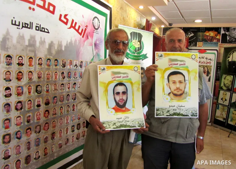 Palestinians hold portraits of relatives jailed in Israeli prisons as they protest to demand for their release,in the old city of Jerusalem on April 23, 2012. Photo by Mahfouz Abu Turk