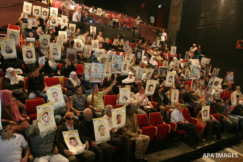 Palestinians hold portraits of relatives jailed in Israeli prisons as they protest to demand for their release,in the old city of Jerusalem on April 23, 2012. Photo by Mahfouz Abu Turk