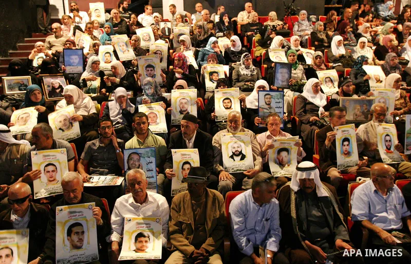 Palestinians hold portraits of relatives jailed in Israeli prisons as they protest to demand for their release,in the old city of Jerusalem on April 23, 2012. Photo by Mahfouz Abu Turk