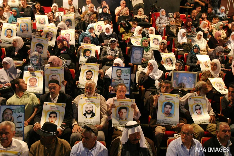 Palestinians hold portraits of relatives jailed in Israeli prisons as they protest to demand for their release,in the old city of Jerusalem on April 23, 2012. Photo by Mahfouz Abu Turk