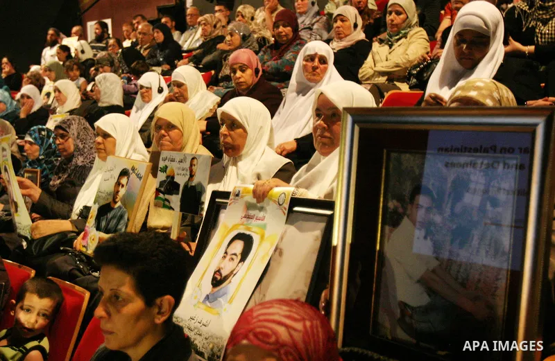 Palestinians hold portraits of relatives jailed in Israeli prisons as they protest to demand for their release,in the old city of Jerusalem on April 23, 2012. Photo by Mahfouz Abu Turk