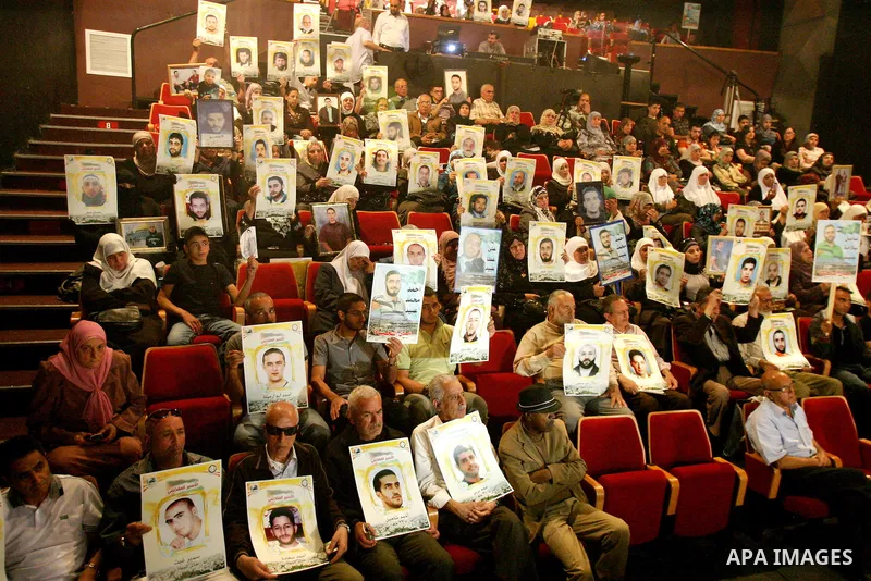 Palestinians hold portraits of relatives jailed in Israeli prisons as they protest to demand for their release,in the old city of Jerusalem on April 23, 2012. Photo by Mahfouz Abu Turk