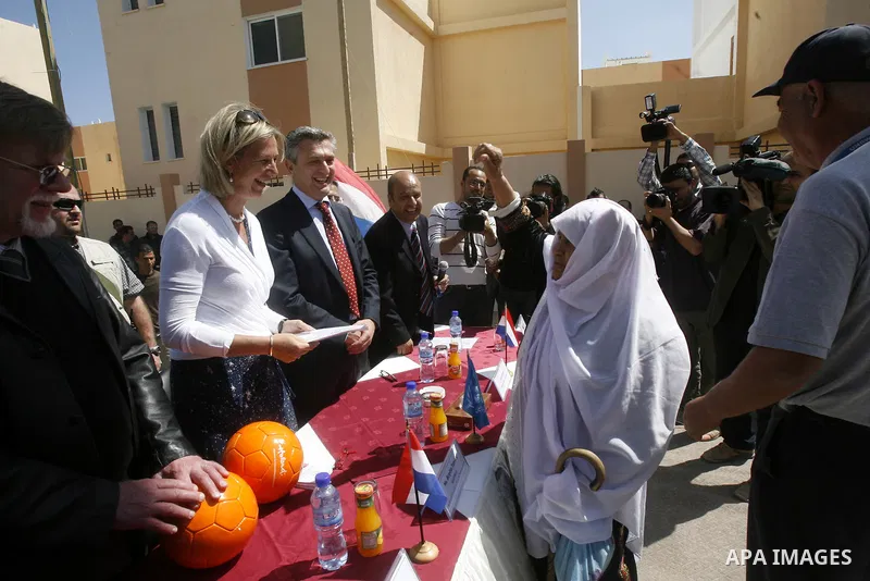 Birgitta Tazelaar, head of Mission of the Netherlands Representation to the Palestinian Authority, watches a Palestinian woman react during a ceremony distributing new homes in Khan Younis in the southern Gaza Strip Apri...