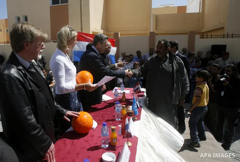 Birgitta Tazelaar, head of Mission of the Netherlands Representation to the Palestinian Authority, watches a Palestinian man react during a ceremony distributing new homes in Khan Younis in the southern Gaza Strip April...