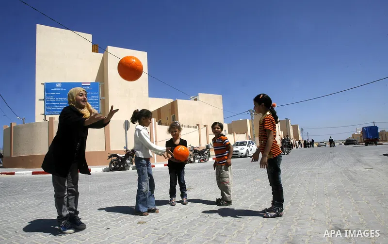 Palestinians Children play during a ceremony distributing new homes in Khan Younis in the southern Gaza Strip April 24, 2012. Palestinians, whose houses were destroyed during Israeli military operations in 2004 and 2005,...