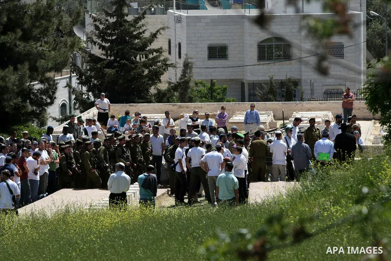 Israeli settler stands during pray in front of a Jewish cemetery near the settlement of Tel Rumeida, in the West Bank City of Hebron, on April 25, 2012. Photo by Mamoun Wazwaz
