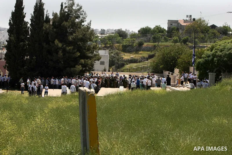 Israeli settler stands during pray in front of a Jewish cemetery near the settlement of Tel Rumeida, in the West Bank City of Hebron, on April 25, 2012. Photo by Mamoun Wazwaz