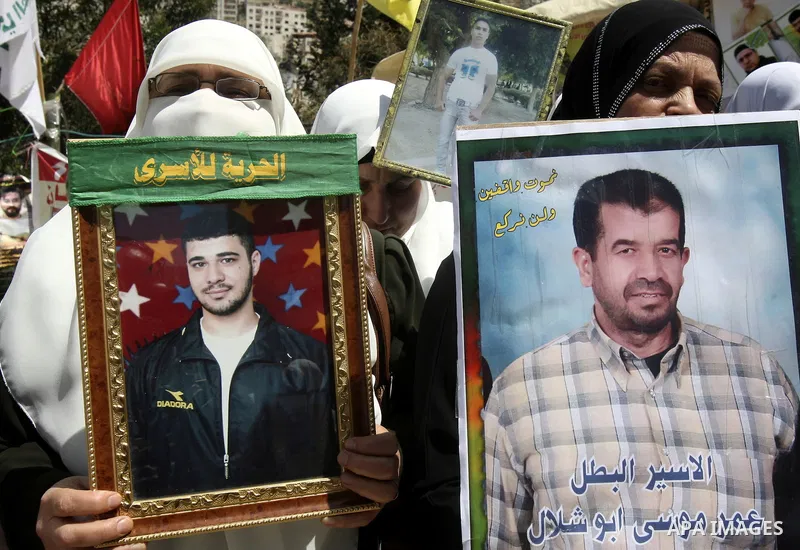 Palestinians hold up portraits of prisoners jailed in Israel during a demonstration calling for their release, in the West Bank city of Nablus on April 25, 2012. Photo by Wagdi Eshtayah