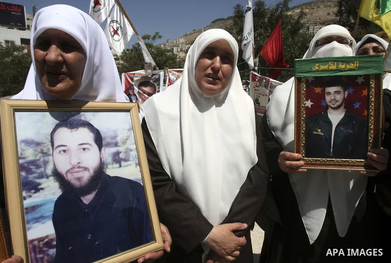 Palestinians hold up portraits of prisoners jailed in Israel during a demonstration calling for their release, in the West Bank city of Nablus on April 25, 2012. Photo by Wagdi Eshtayah