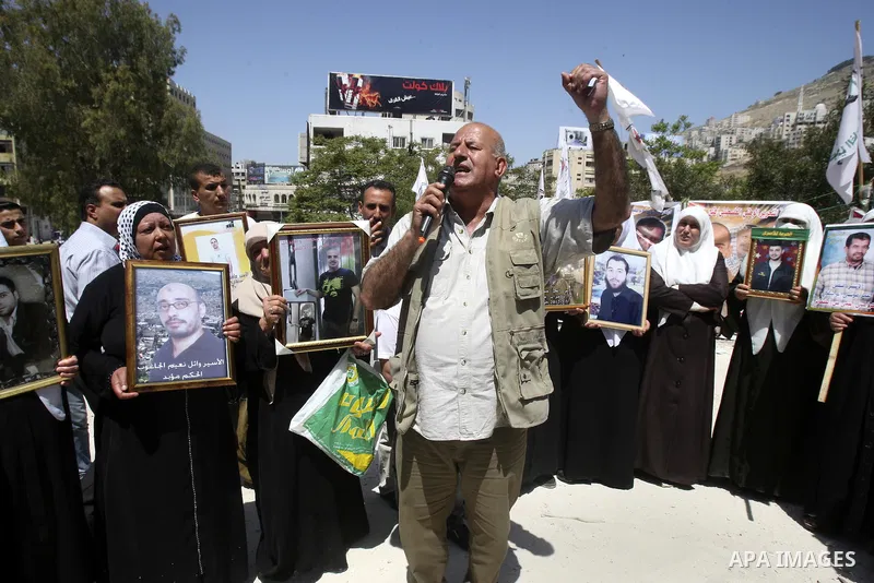 Palestinians hold up portraits of prisoners jailed in Israel during a demonstration calling for their release, in the West Bank city of Nablus on April 25, 2012. Photo by Wagdi Eshtayah