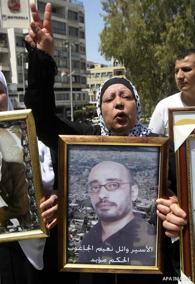 Palestinians hold up portraits of prisoners jailed in Israel during a demonstration calling for their release, in the West Bank city of Nablus on April 25, 2012. Photo by Wagdi Eshtayah