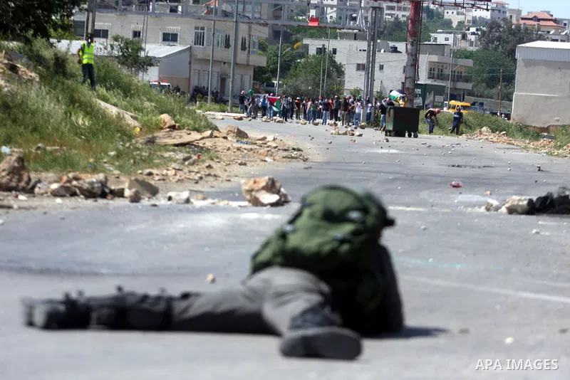 An Israeli soldier fires rubber bullets at Palestinian protesters during clashes at the Bitwonia crossing outside the Israeli military prison of Ofer, on Israel's 64th Independence Day, 26 April 2012. Palestinians staged...