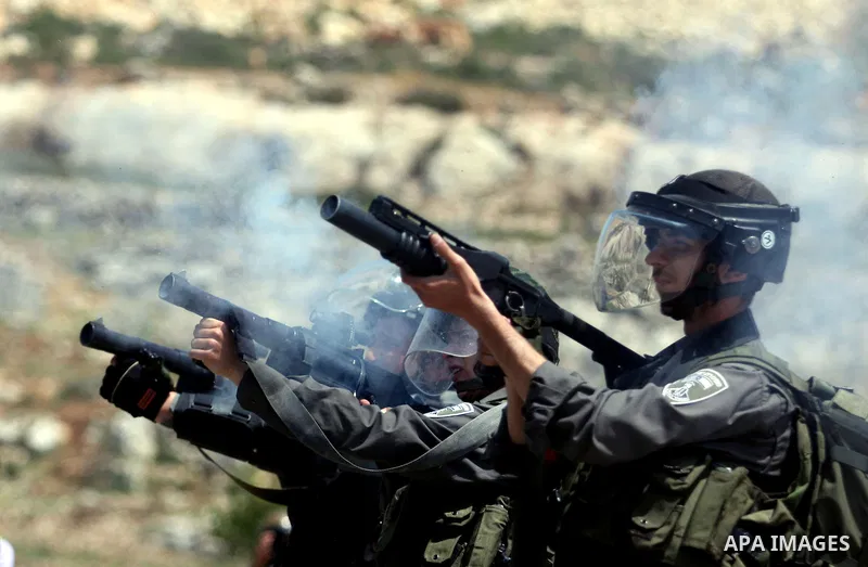 Israeli soldiers fire tear gas during clashes at the Bitwonia crossing outside the Israeli military prison of Ofer, on Israel's 64th Independence Day, 26 April 2012. Palestinians staged their protest near the Ofer prison...