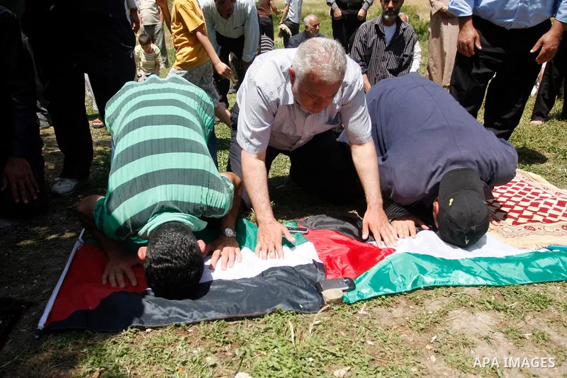 Palestinians pray during a protest against land confiscation by nearby Jewish settlements, Wadi Qana, in the West Bank village Deir Istia , Friday, April 27, 2012 . Photo by Wagdi Eshtayah