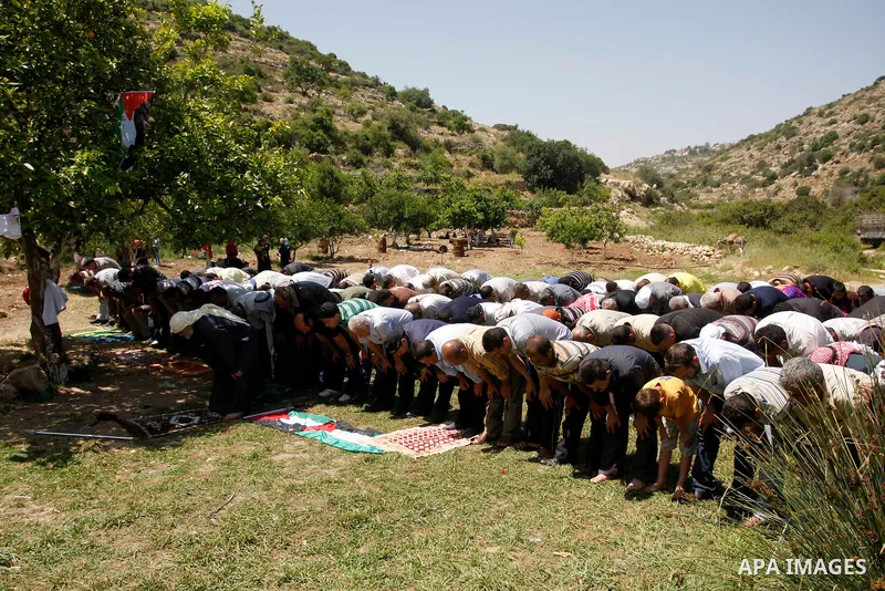 Palestinians pray during a protest against land confiscation by nearby Jewish settlements, Wadi Qana, in the West Bank village Deir Istia , Friday, April 27, 2012 . Photo by Wagdi Eshtayah