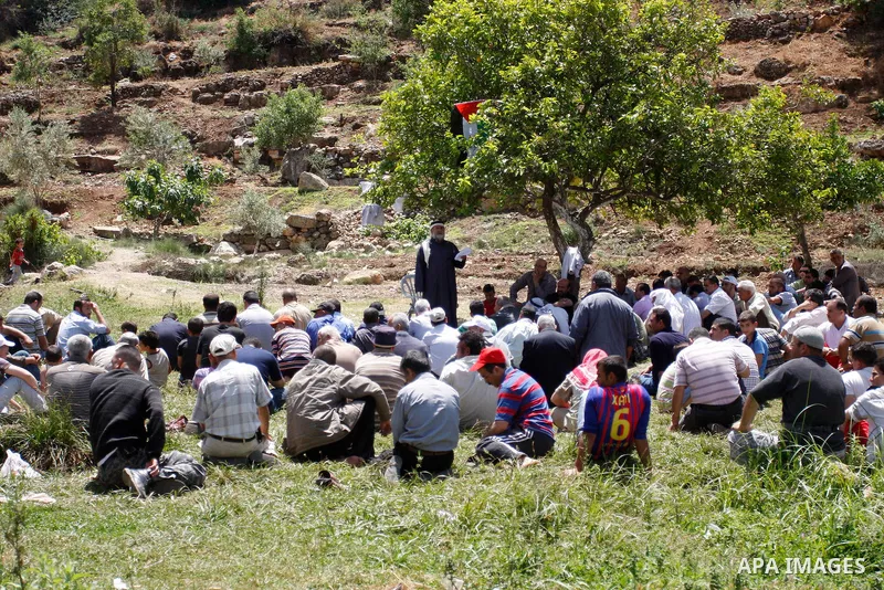 Palestinians pray during a protest against land confiscation by nearby Jewish settlements, Wadi Qana, in the West Bank village Deir Istia , Friday, April 27, 2012 . Photo by Wagdi Eshtayah