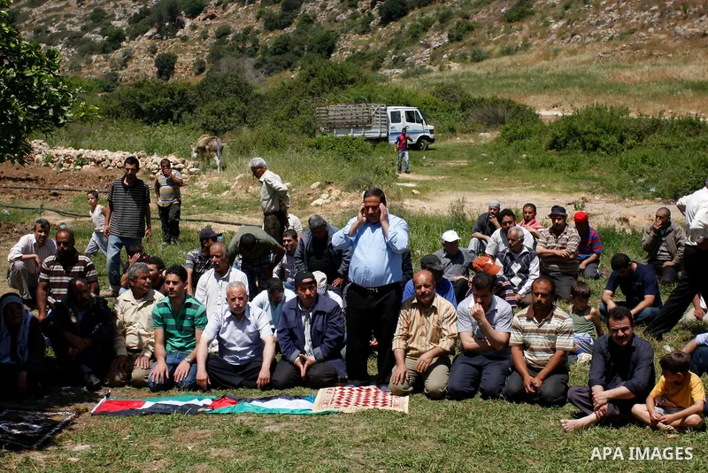 Palestinians pray during a protest against land confiscation by nearby Jewish settlements, Wadi Qana, in the West Bank village Deir Istia , Friday, April 27, 2012 . Photo by Wagdi Eshtayah
