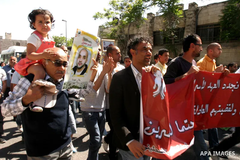 Palestinians hold portraits of relatives jailed in Israeli prisons as they protest to demand for their release, in the Al Aqsa Mosque compound in Jerusalem's Old City, on April 27, 2012. After decades of shying away from...