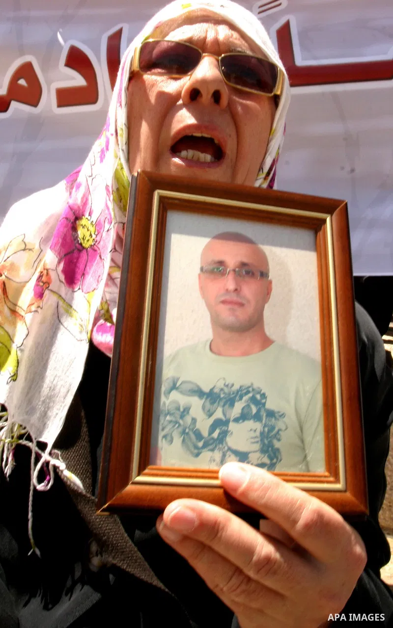 Palestinians hold portraits of relatives jailed in Israeli prisons as they protest to demand for their release, in the Al Aqsa Mosque compound in Jerusalem's Old City, on April 27, 2012. After decades of shying away from...