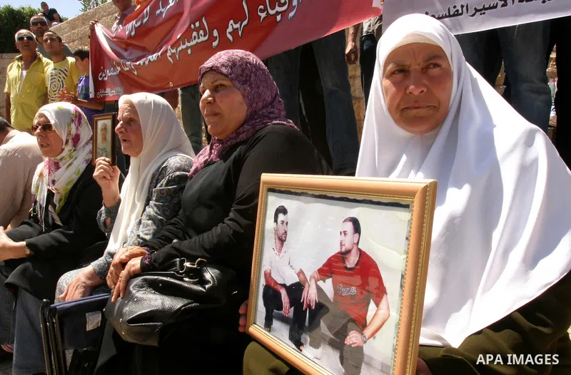Palestinians hold portraits of relatives jailed in Israeli prisons as they protest to demand for their release, in the Al Aqsa Mosque compound in Jerusalem's Old City, on April 27, 2012. After decades of shying away from...