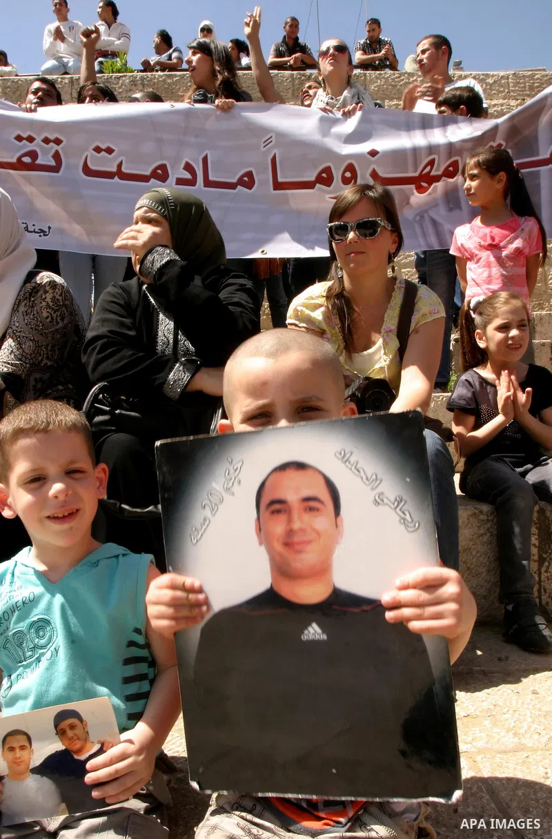Palestinians hold portraits of relatives jailed in Israeli prisons as they protest to demand for their release, in the Al Aqsa Mosque compound in Jerusalem's Old City, on April 27, 2012. After decades of shying away from...