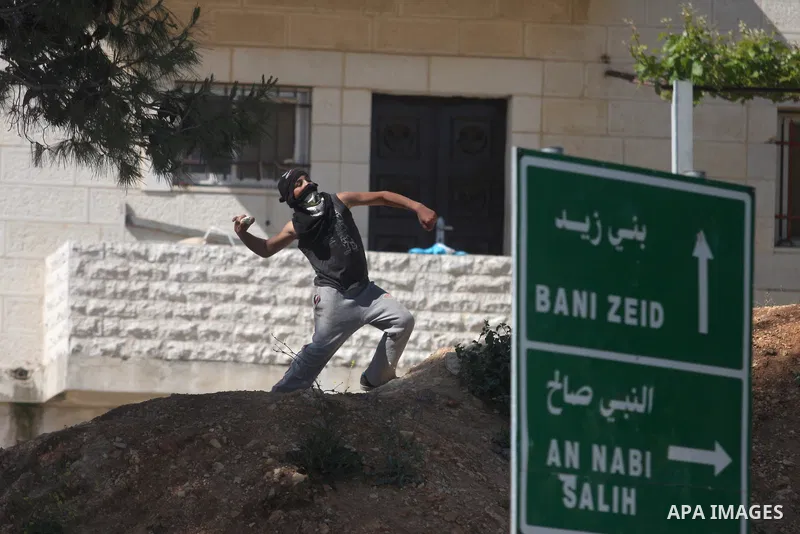 Palestinian youths and Israeli troops clash during a weekly demonstration against the expansion of the nearby Jewish settlement of Halamish in the West Bank village of Nabi Saleh near Ramallah, Friday, April 27, 2012. Ph...