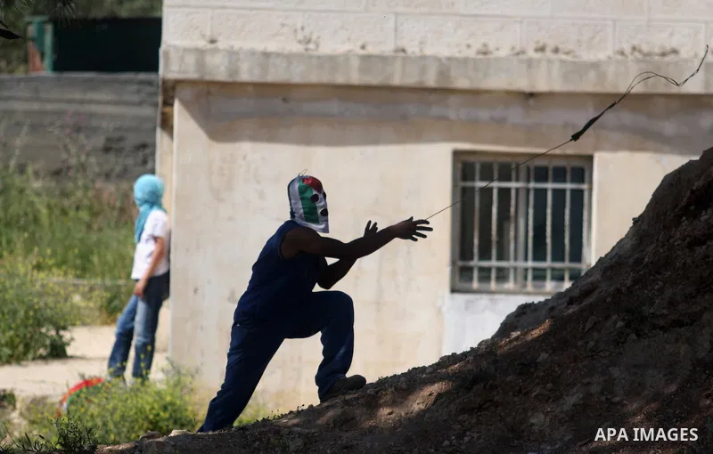 Palestinian youths and Israeli troops clash during a weekly demonstration against the expansion of the nearby Jewish settlement of Halamish in the West Bank village of Nabi Saleh near Ramallah, Friday, April 27, 2012. Ph...