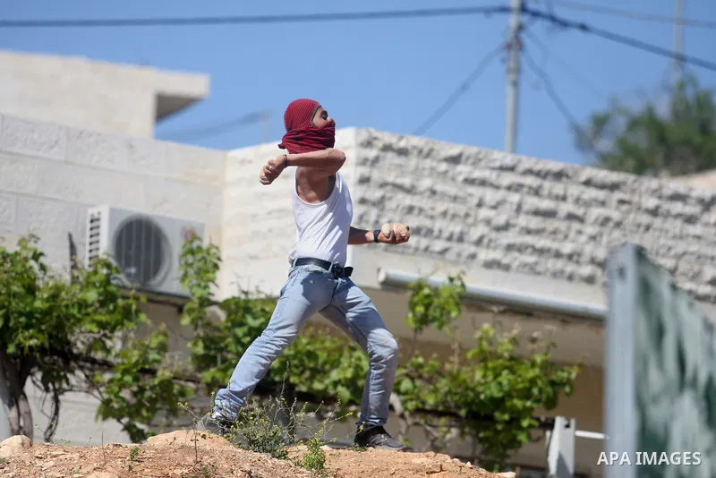 Palestinian youths and Israeli troops clash during a weekly demonstration against the expansion of the nearby Jewish settlement of Halamish in the West Bank village of Nabi Saleh near Ramallah, Friday, April 27, 2012. Ph...
