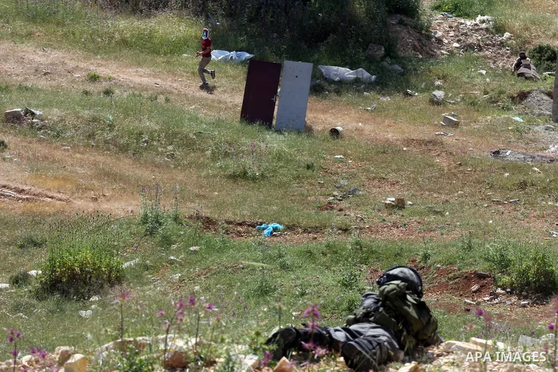 Palestinian youths and Israeli troops clash during a weekly demonstration against the expansion of the nearby Jewish settlement of Halamish in the West Bank village of Nabi Saleh near Ramallah, Friday, April 27, 2012. Ph...