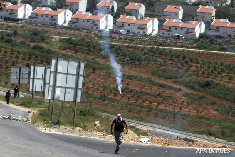 Palestinian youths and Israeli troops clash during a weekly demonstration against the expansion of the nearby Jewish settlement of Halamish in the West Bank village of Nabi Saleh near Ramallah, Friday, April 27, 2012. Ph...