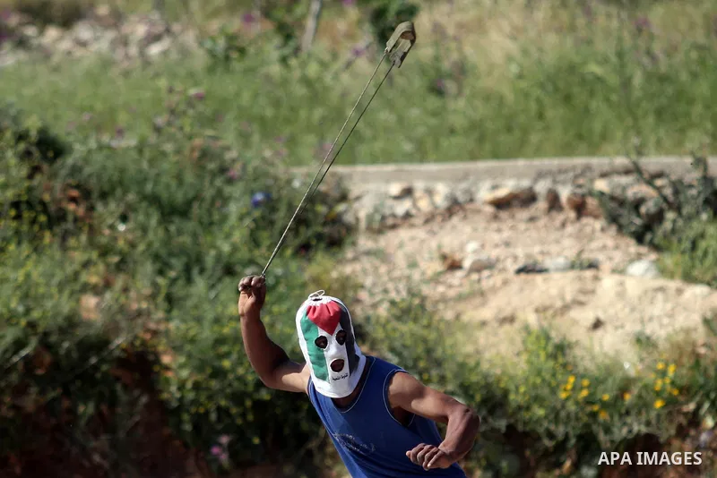 Palestinian youths and Israeli troops clash during a weekly demonstration against the expansion of the nearby Jewish settlement of Halamish in the West Bank village of Nabi Saleh near Ramallah, Friday, April 27, 2012. Ph...