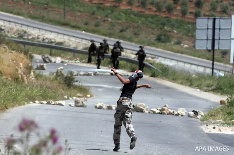 Palestinian youths and Israeli troops clash during a weekly demonstration against the expansion of the nearby Jewish settlement of Halamish in the West Bank village of Nabi Saleh near Ramallah, Friday, April 27, 2012. Ph...