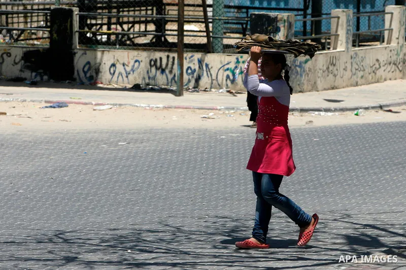 A Palestinian girl walks to the traditional mud oven to bake loaves of bread, in Rafah refugee camp, southern Gaza Strip on April 28, 2012. Photo by Eyad Al Baba