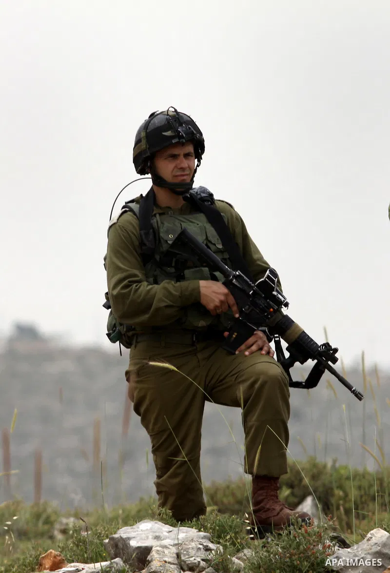 Israeli soldiers stand between Palestinian farmers and jewish settlers after clashes in Qusra village near the west bank city of Nablus, on April 29, 2012. Photo by Nedal Shtieh